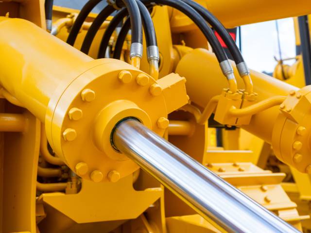 A large yellow machine with hydraulic tubes coming out of it, as well as pistons and force torque sensors.